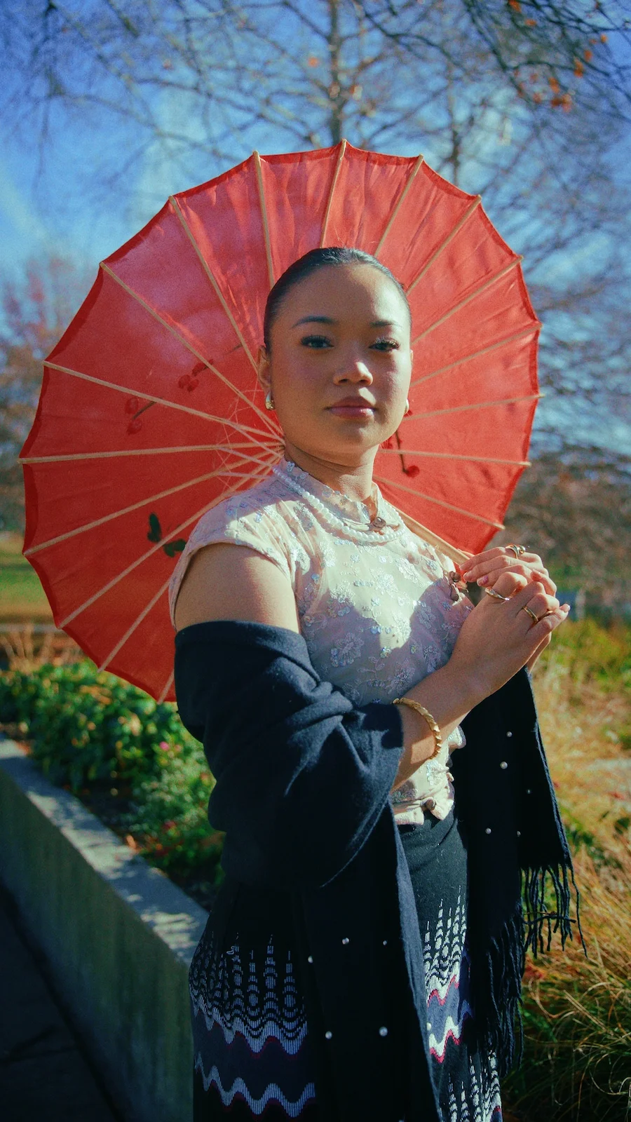 Creative portrait photography in Kansas City featuring woman with red umbrella outdoors