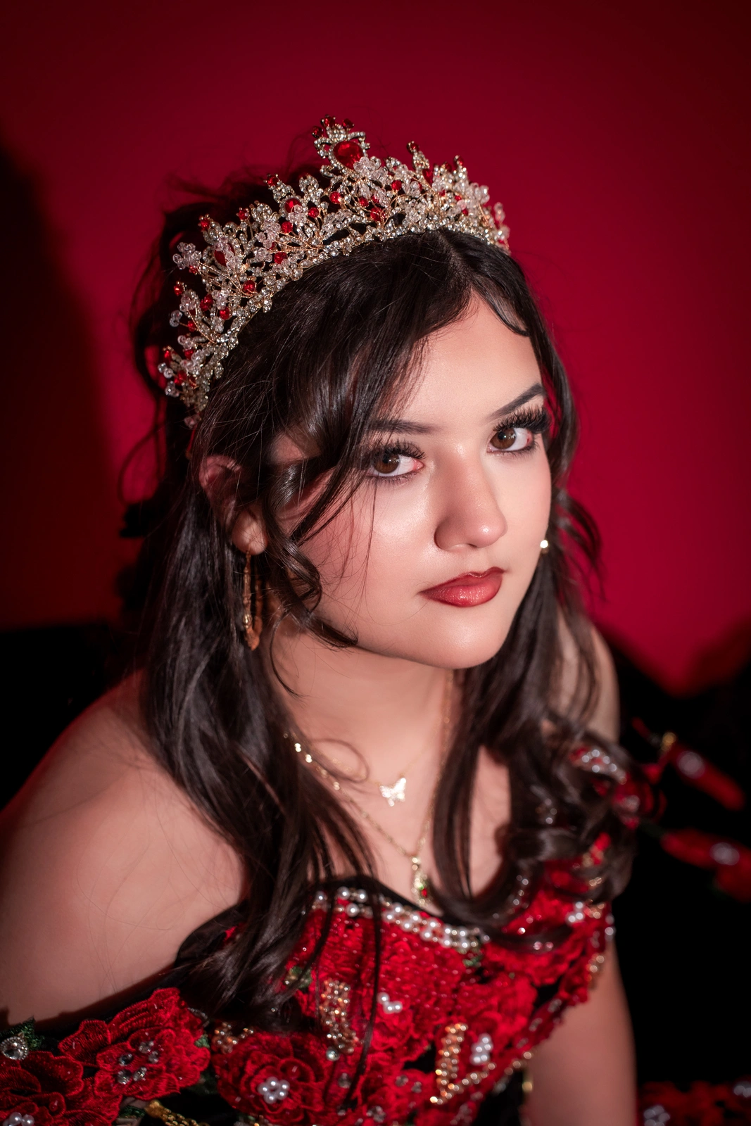 Close-up quinceañera portrait in Kansas City wearing crown and black red dress