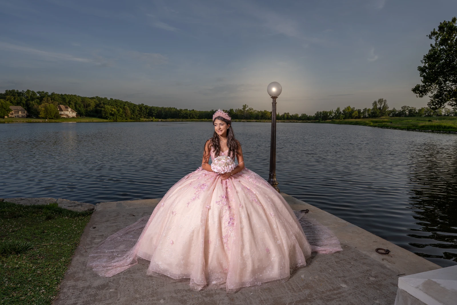 Wide quinceañera portrait in Kansas City by lake at sunset with pink dress