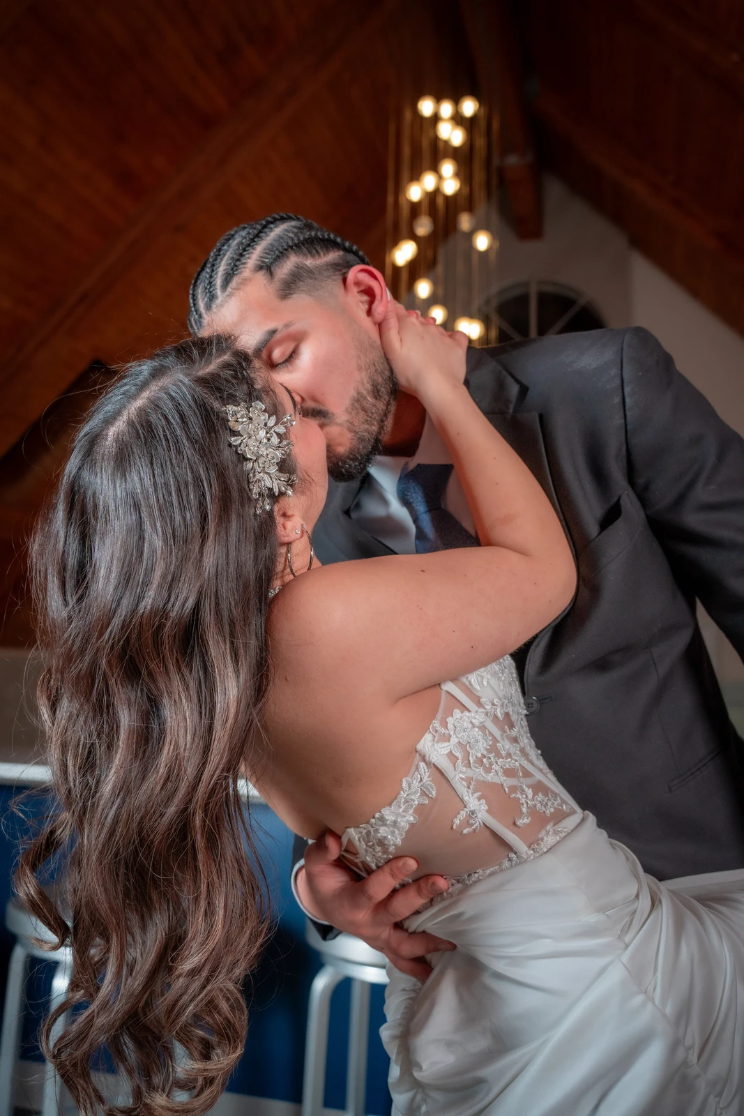 Bride and groom sharing a romantic kiss indoors with warm lighting during Kansas City wedding