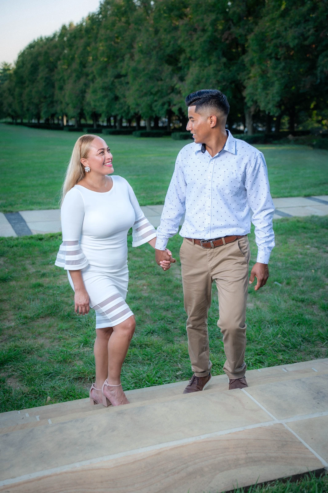 Bride and groom walking together holding hands during outdoor wedding session in Kansas City