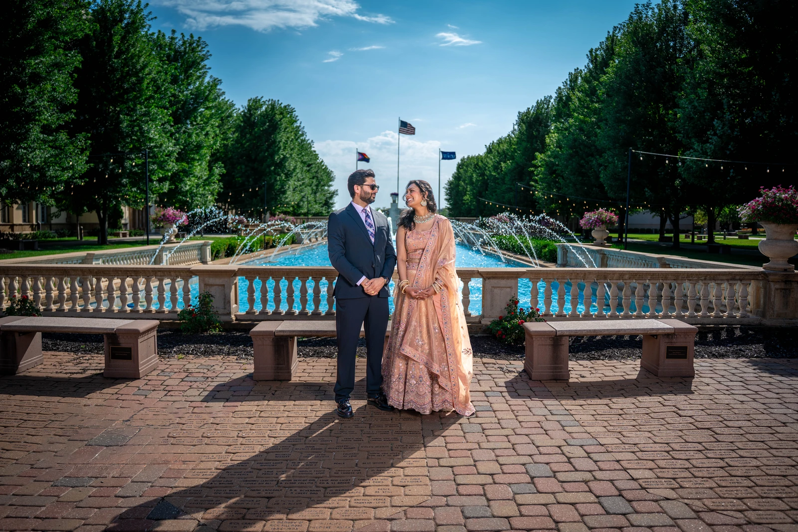 Indian wedding couple standing in front of fountain during outdoor photos in Kansas City